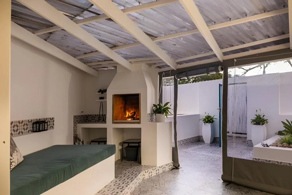 Covered patio with fireplace, seating, and views to enclosed courtyard