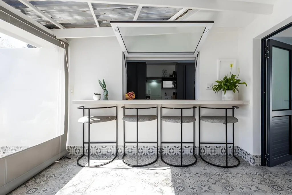 Modern bar counter with four stools and potted plants indoors