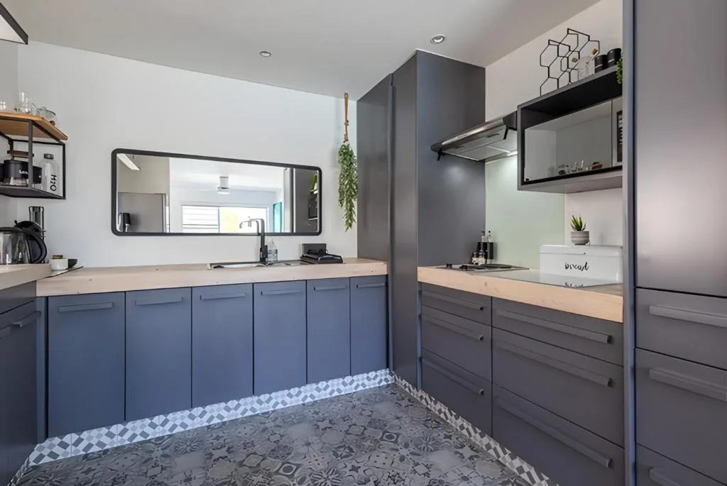 Modern kitchen with blue cabinetry, wooden countertops, stainless steel appliances