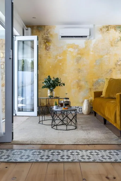 Modern lounge with mustard velvet sofa and textured gold accent wall