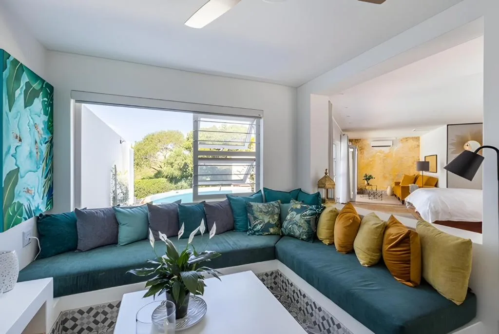 Modern lounge with teal sectional sofa and ocean views through glass doors