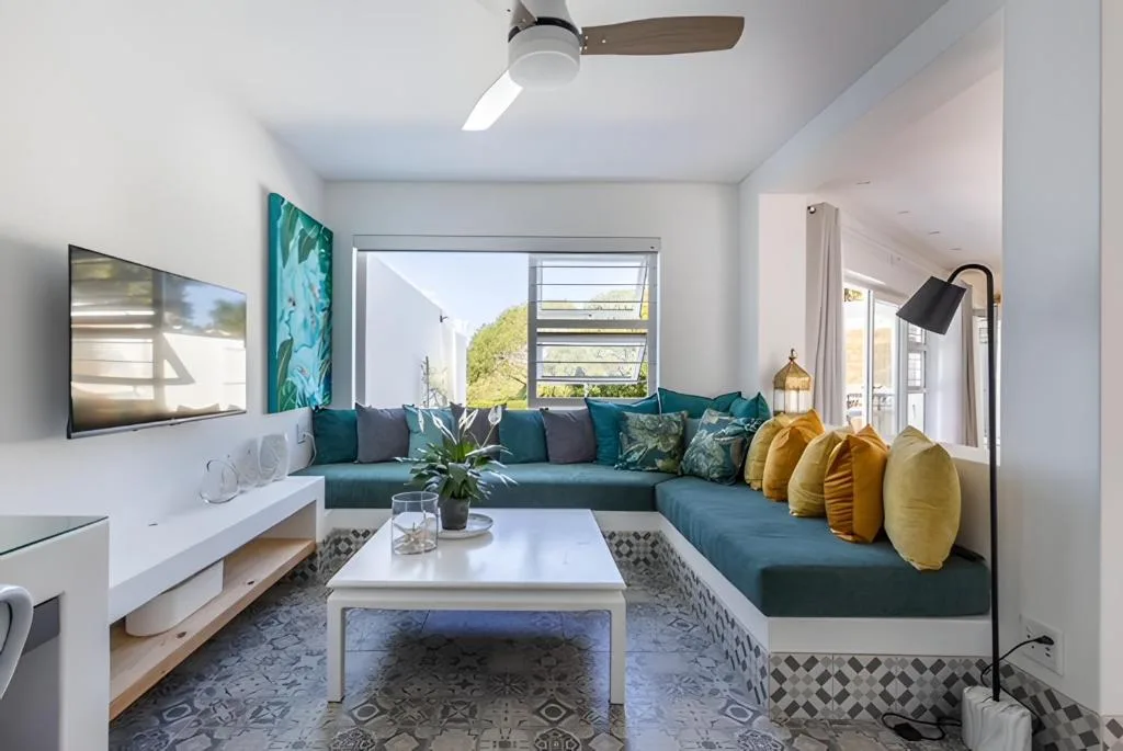 Modern living room with teal sectional sofa and ocean views through large windows