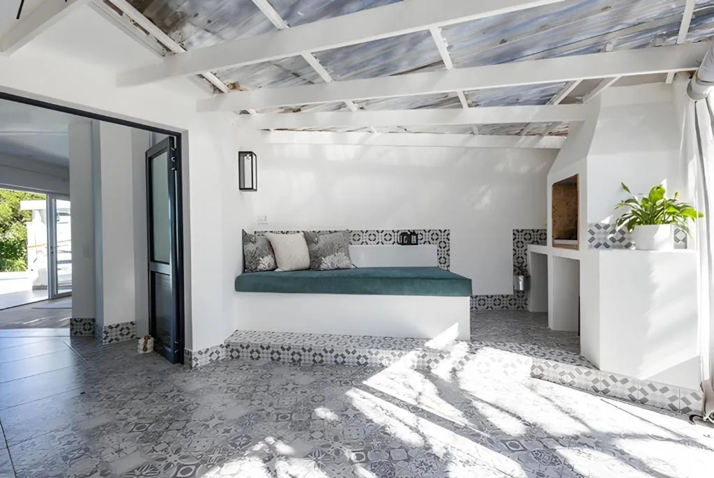 Bright modern lounge with teal seating, patterned tiles, and skylights