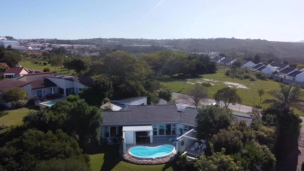 Aerial view of modern home with pool overlooking green valleys and coastal landscape