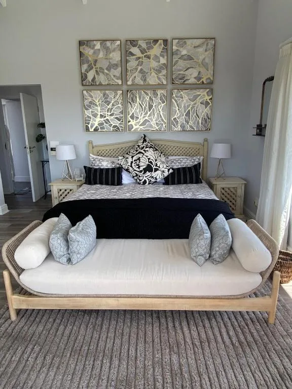 Stylish bedroom with upholstered bed, botanical wall art, modern decor