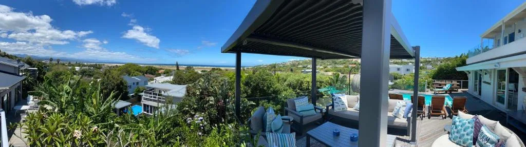 Modern pergola deck with lounge seating overlooking lush garden landscape