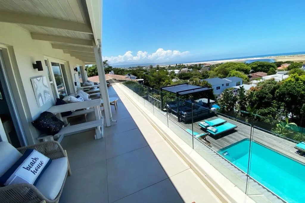 Spacious coastal deck with ocean views, pool, and lounging areas