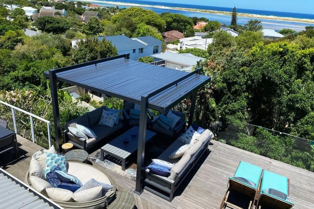 Elevated deck with modern pergola, lounge seating, ocean and lagoon views