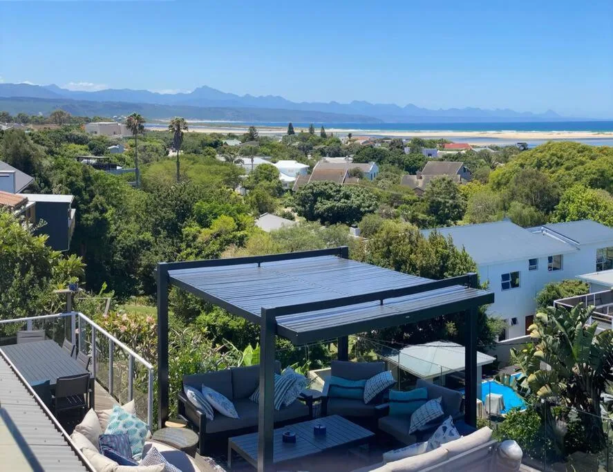 Panoramic coastal vista with mountains, beach, and lagoon from elevated deck