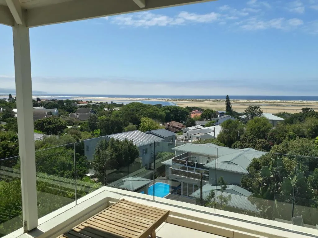 Expansive coastal landscape with lagoon, farmland, and ocean from elevated deck