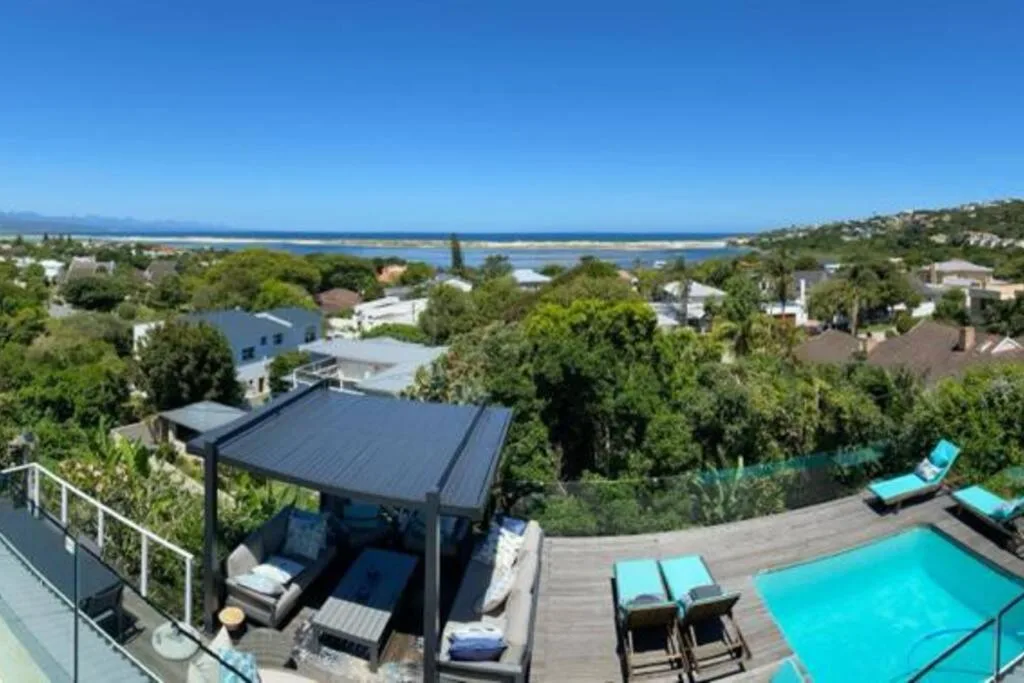 Panoramic lagoon and coastal view from elevated deck with pool