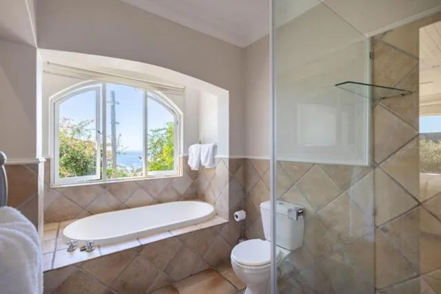 Bathroom with soaking tub, shower enclosure, and mountain view window