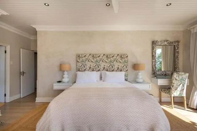 Spacious bedroom with queen bed, matching bedside tables, and natural light