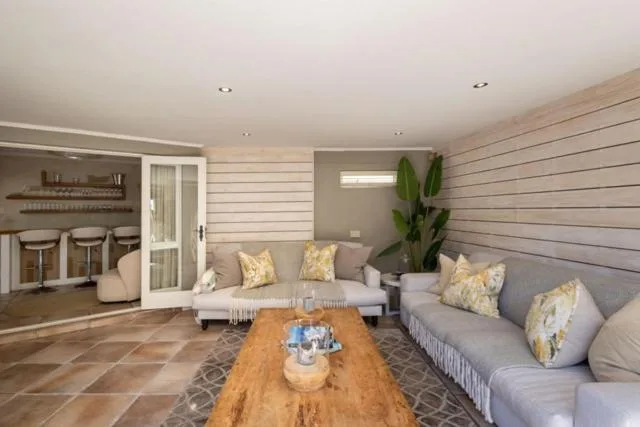 Spacious lounge with gray sofas, wooden coffee table, and potted plants