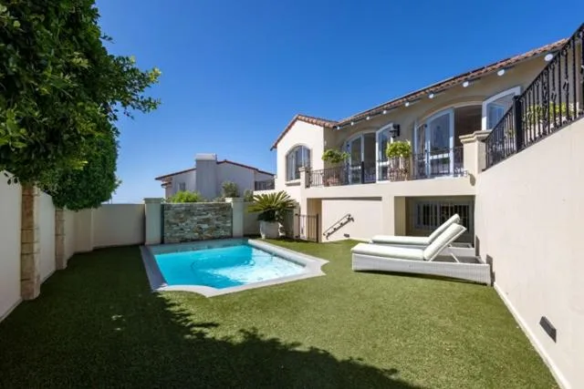 Sparkling swimming pool in manicured garden with modern house backdrop