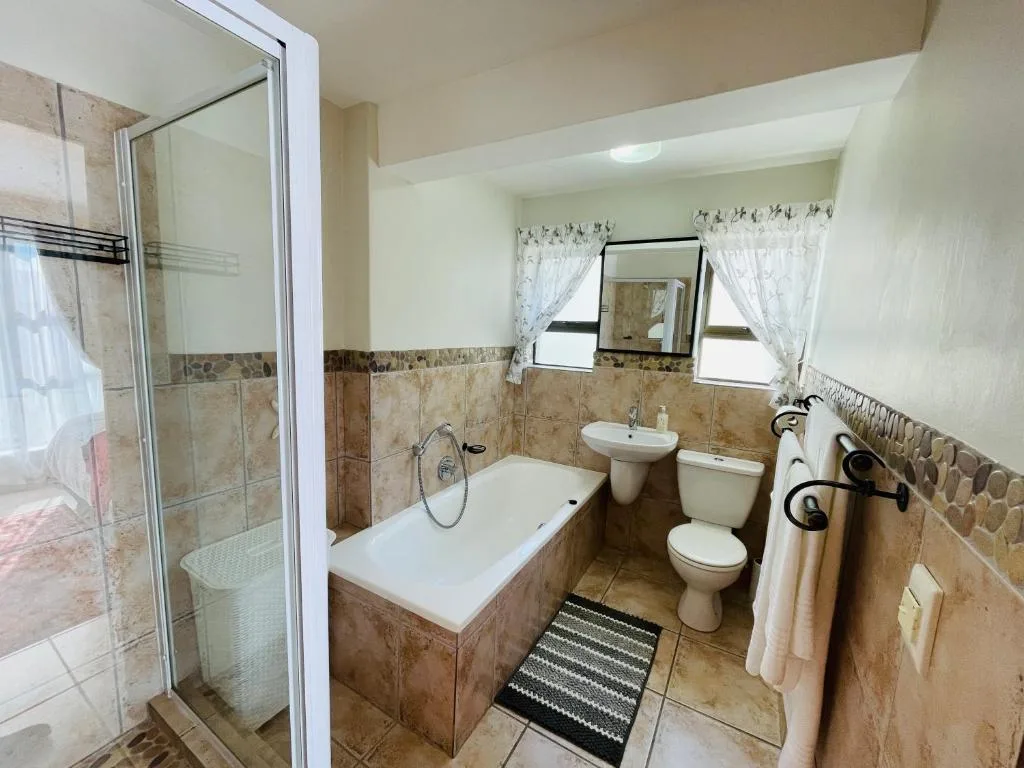 Bathroom with bathtub, shower, toilet, vanity sink and mirror
