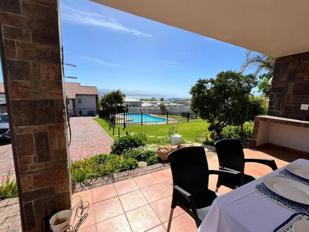 Terracotta patio with seating overlooking pool and garden views