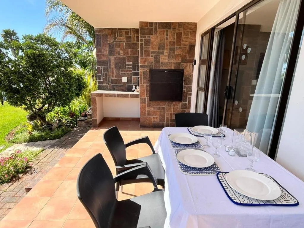Outdoor patio area with set dining table and garden views