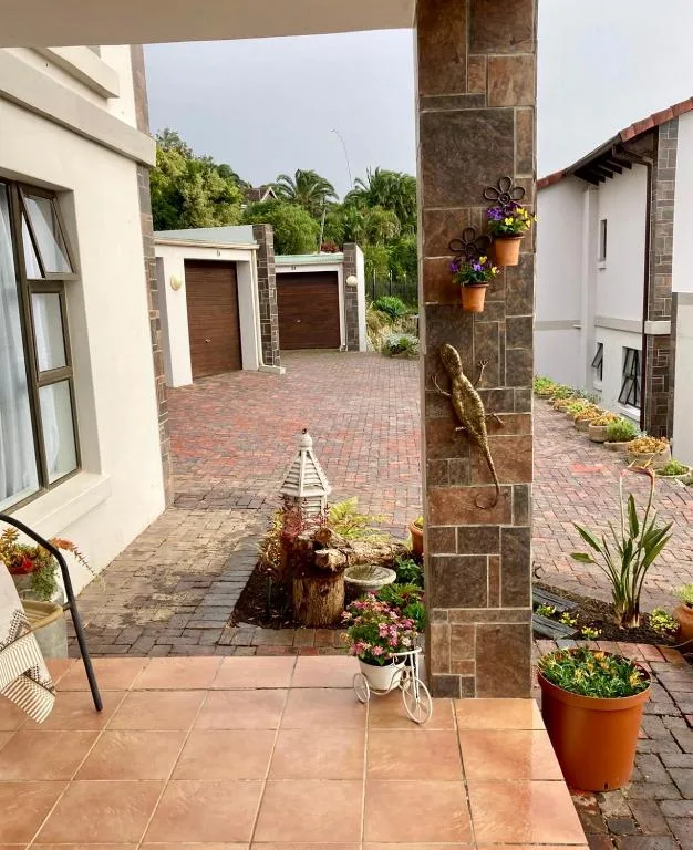 Driveway with double garage doors and manicured garden landscaping