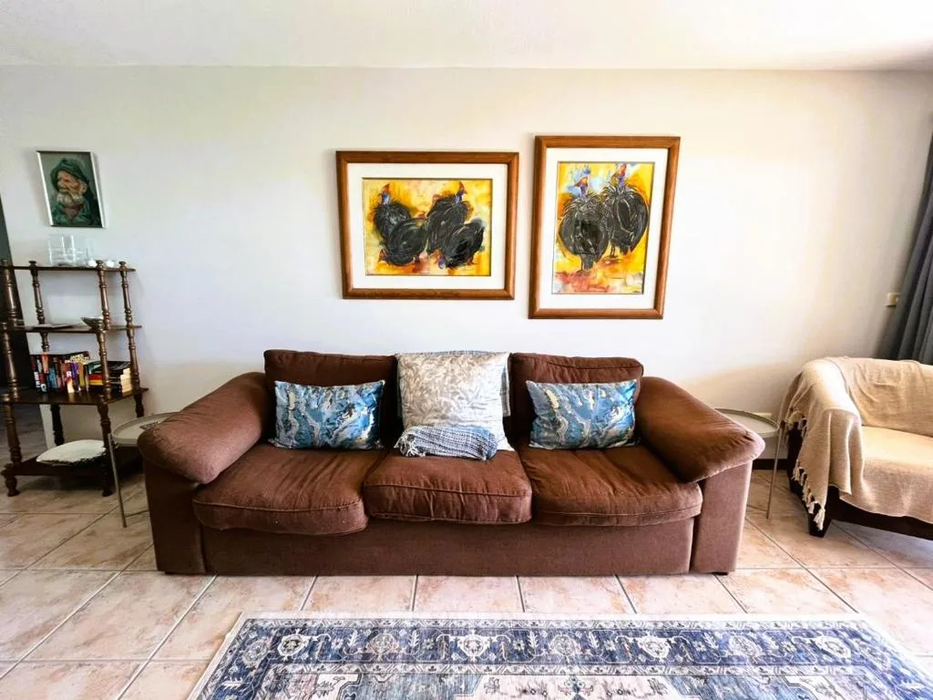 Brown leather sofa with decorative pillows in bright living room