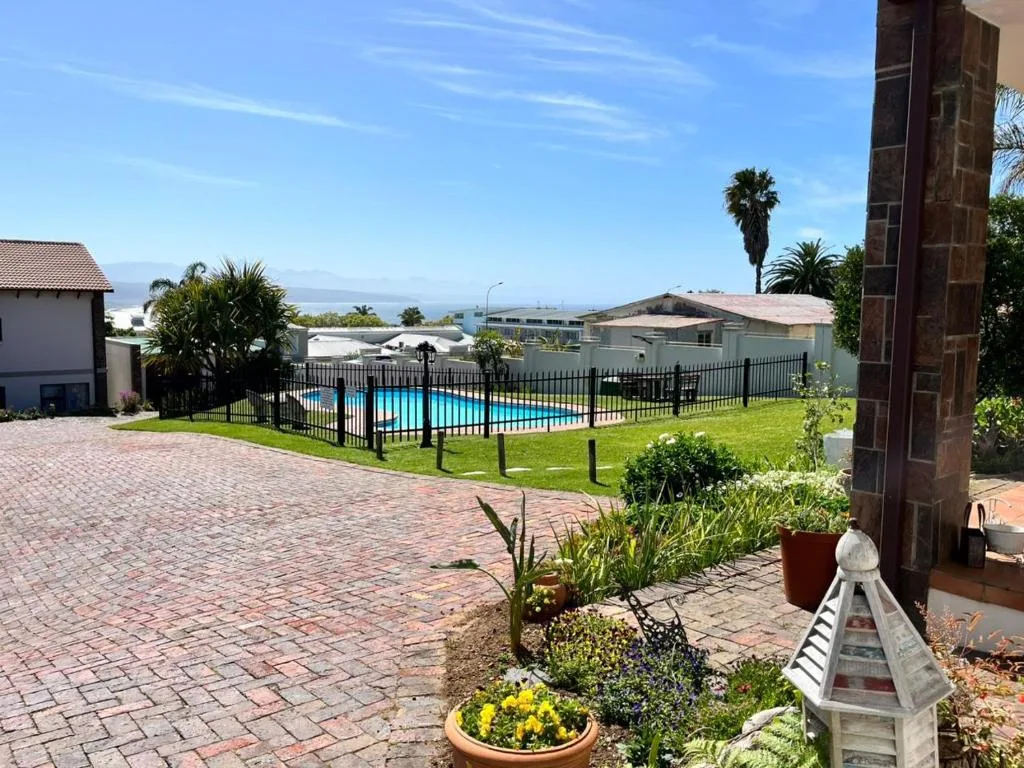 Fenced swimming pool with mountain views and surrounding green lawn area