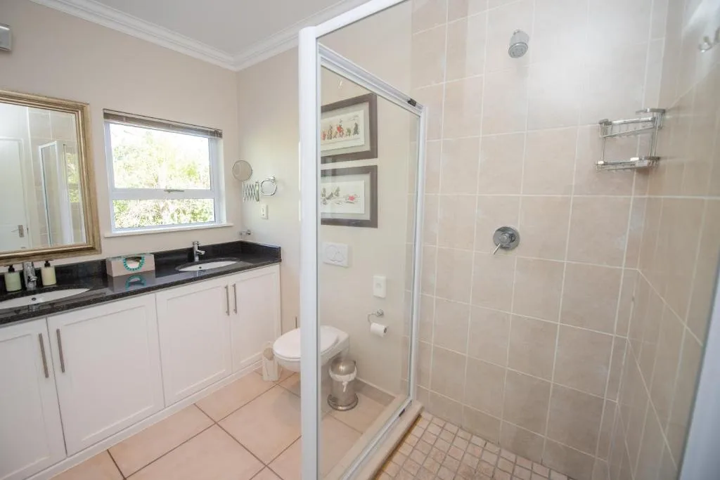 Spacious bathroom with vanity, toilet, and walk-in shower enclosure