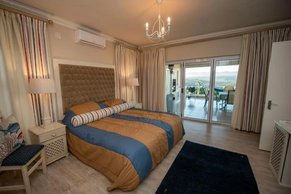 Spacious bedroom with king bed, elegant furnishings, and scenic views through patio doors