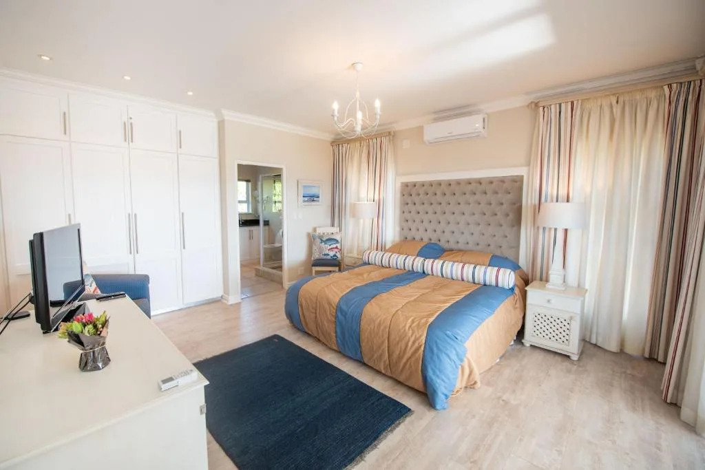 Spacious bedroom with queen bed, built-in wardrobes, and elegant furnishings