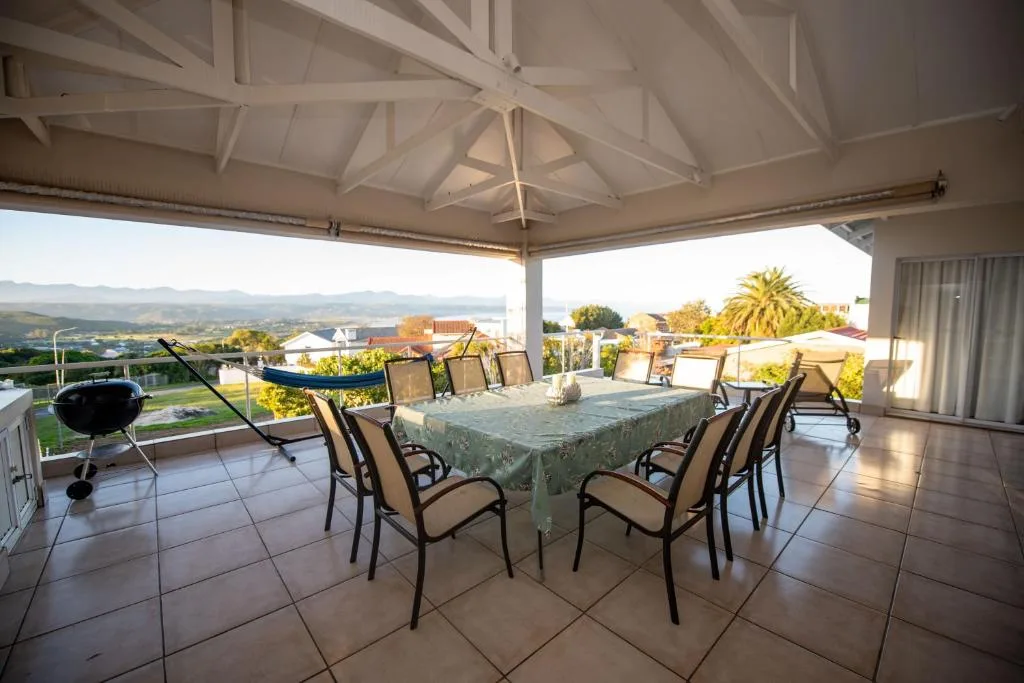 Covered patio with dining table, braai, and panoramic valley views