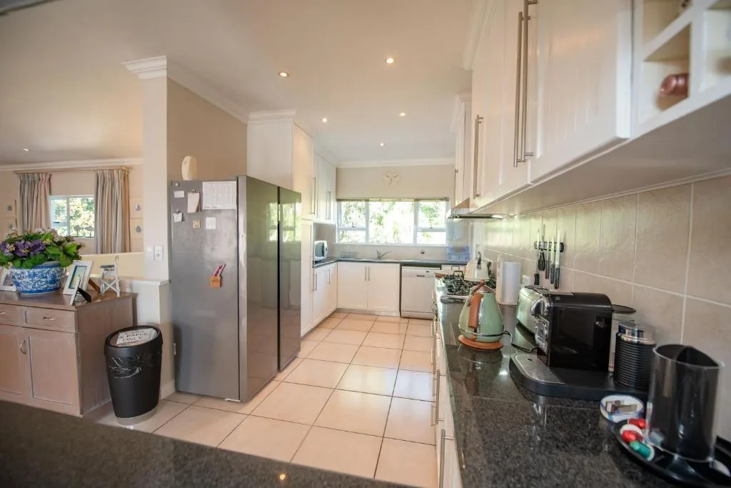 Modern kitchen with white cabinetry, stainless steel appliances, and tile flooring