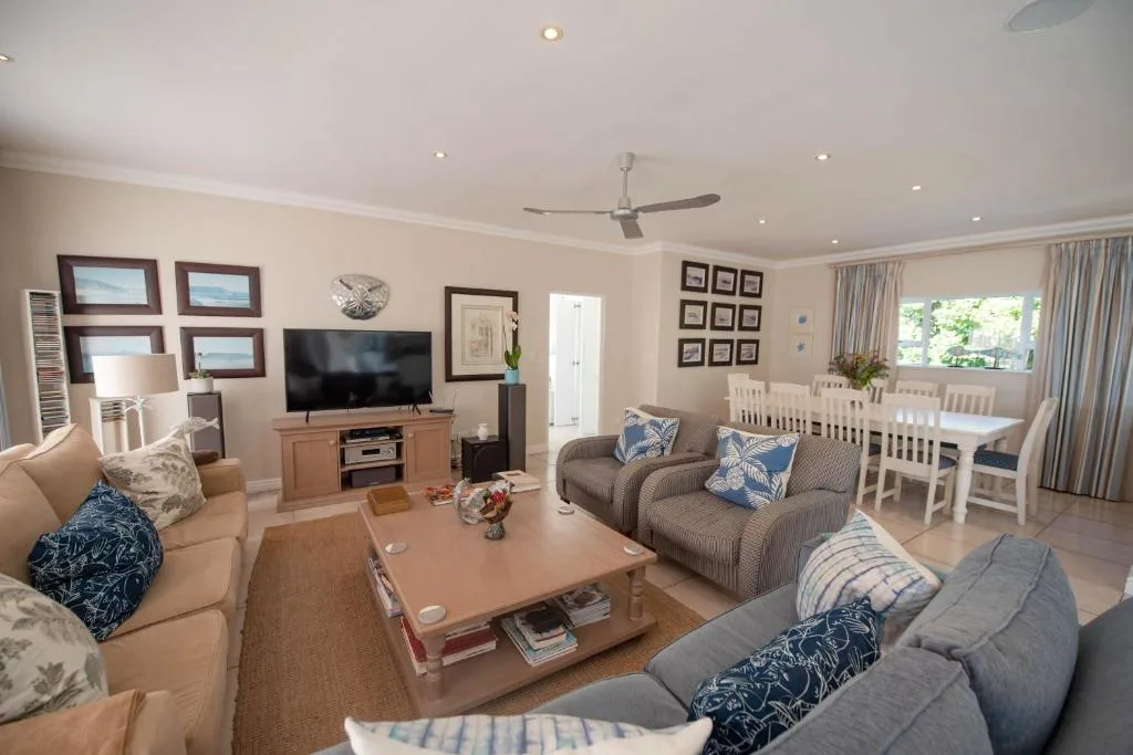 Spacious open-plan lounge with comfortable sofas, TV, and dining area visible