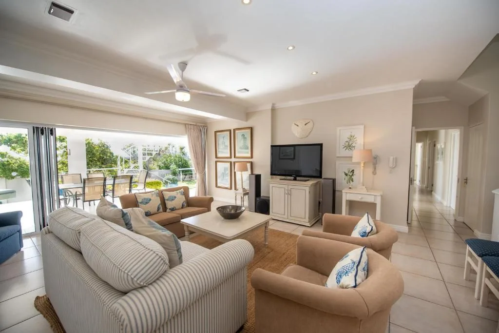 Spacious living room with comfortable seating and television overlooking deck