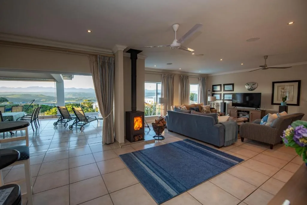 Spacious lounge with fireplace, comfortable seating, and expansive garden route views