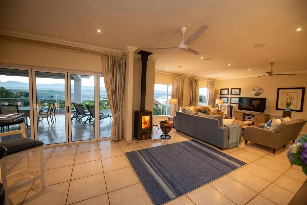 Spacious lounge with fireplace, comfortable seating, and expansive views through glass doors