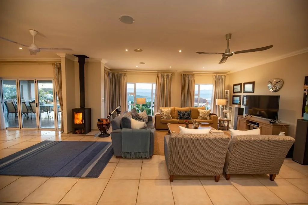 Spacious open-plan lounge with fireplace, comfortable seating, and ocean views