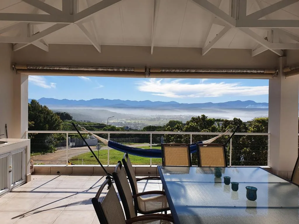 Mountain and valley vista from covered deck with dining furniture