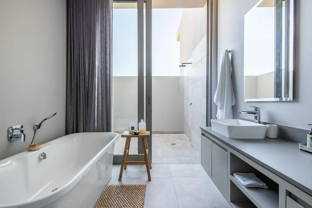 Modern bathroom with freestanding bathtub, dual vanity, and glass shower enclosure