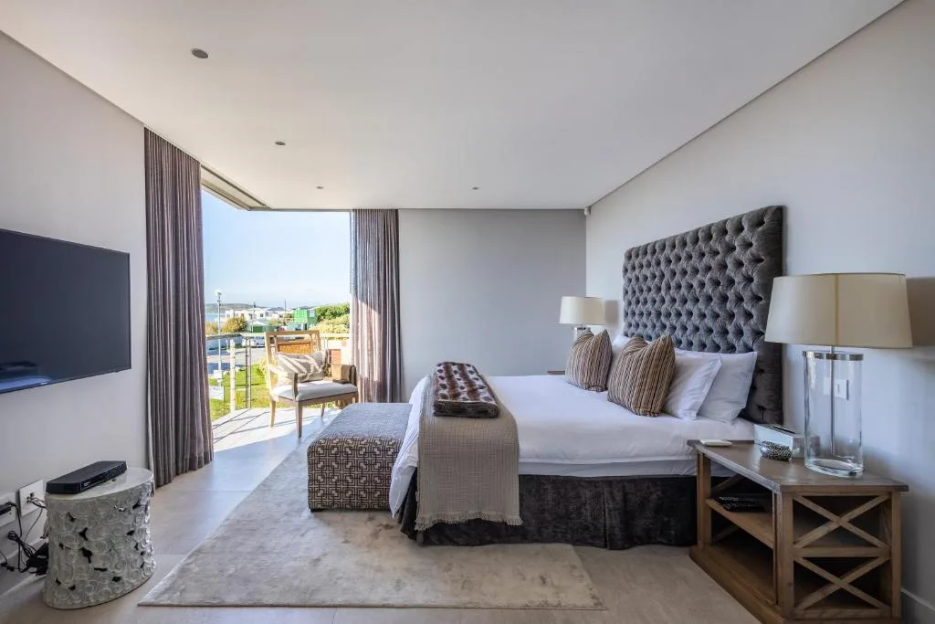 Luxurious bedroom with king bed, view to garden and lagoon beyond