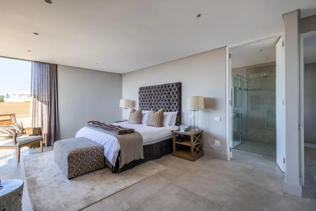 Modern bedroom with bed, upholstered headboard, and ensuite bathroom access