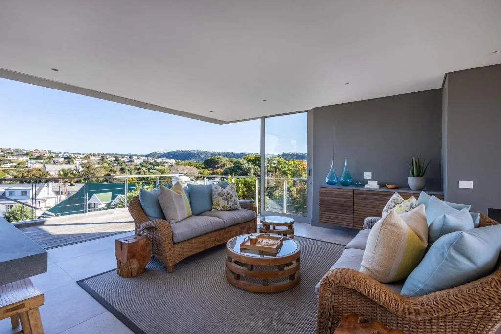 Covered outdoor lounge area with wicker seating and expansive lagoon views
