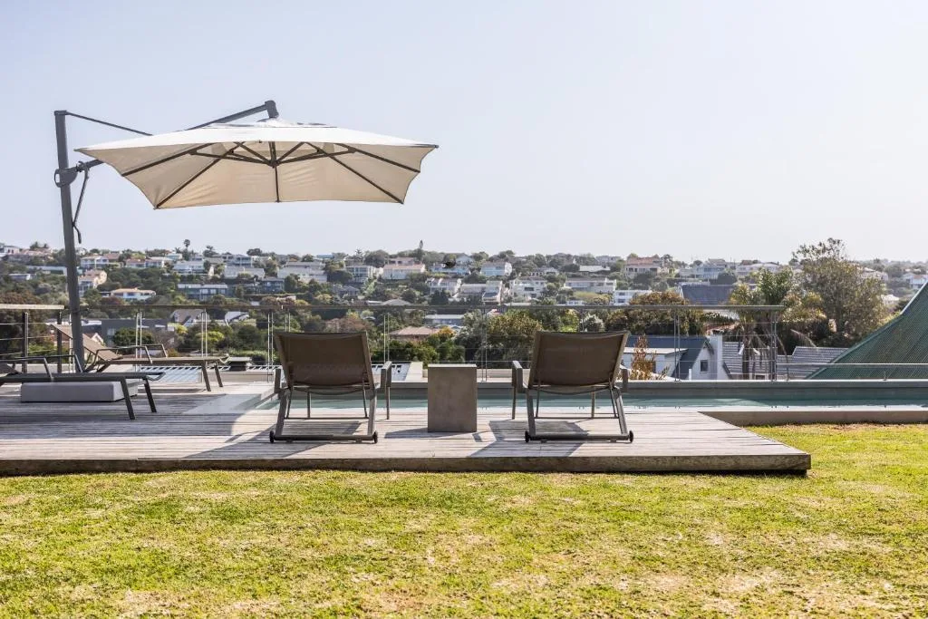Shaded outdoor seating area with cantilever umbrella overlooking coastal town