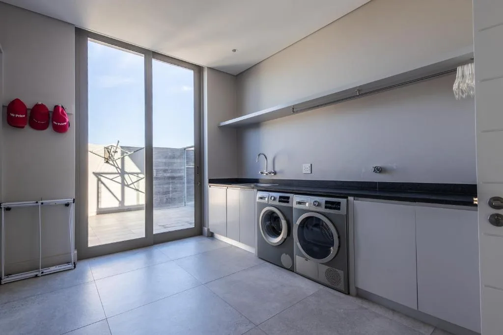 Modern laundry room with washer and dryer appliances and deck access
