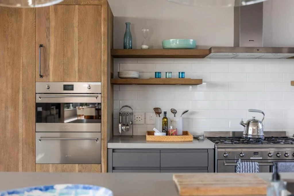 Modern kitchen with wooden cabinetry, stainless steel appliances, and open shelving