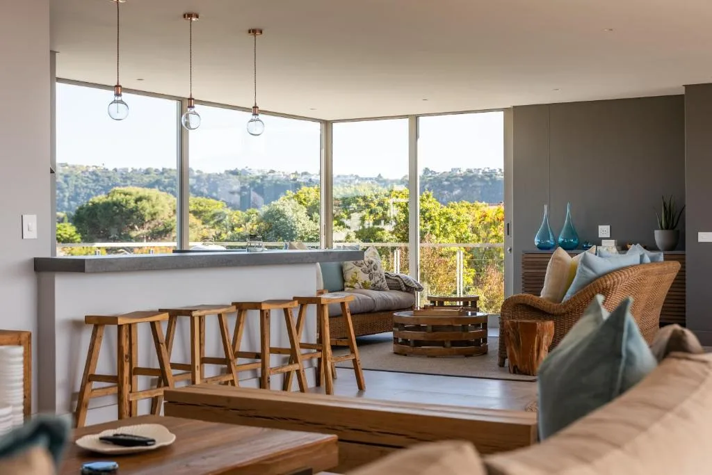 Modern lounge with panoramic windows overlooking lush garden landscape