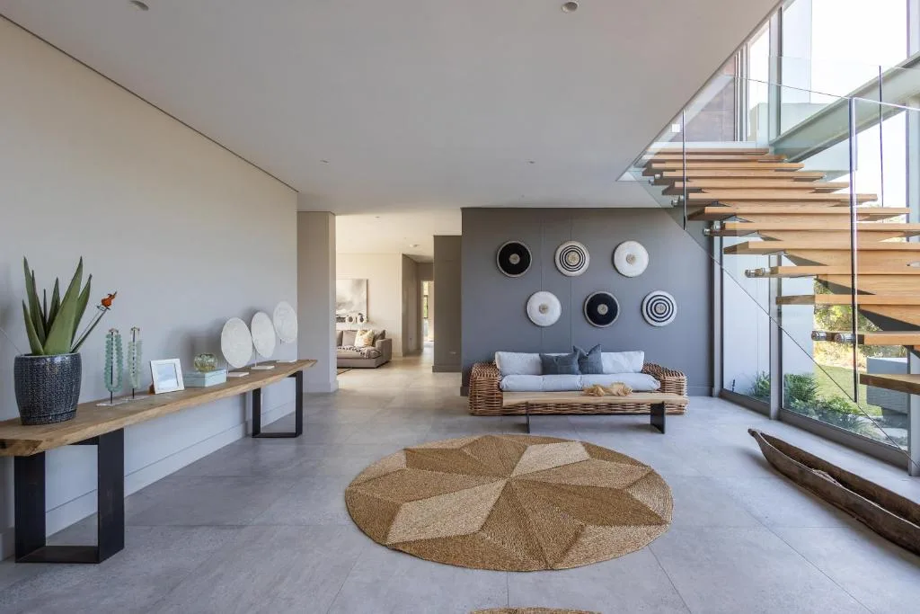 Modern lounge with rattan sofa, decorative wall plates, and geometric rug