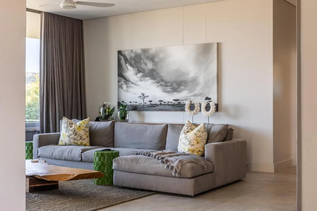 Modern living room with gray sectional sofa and landscape artwork