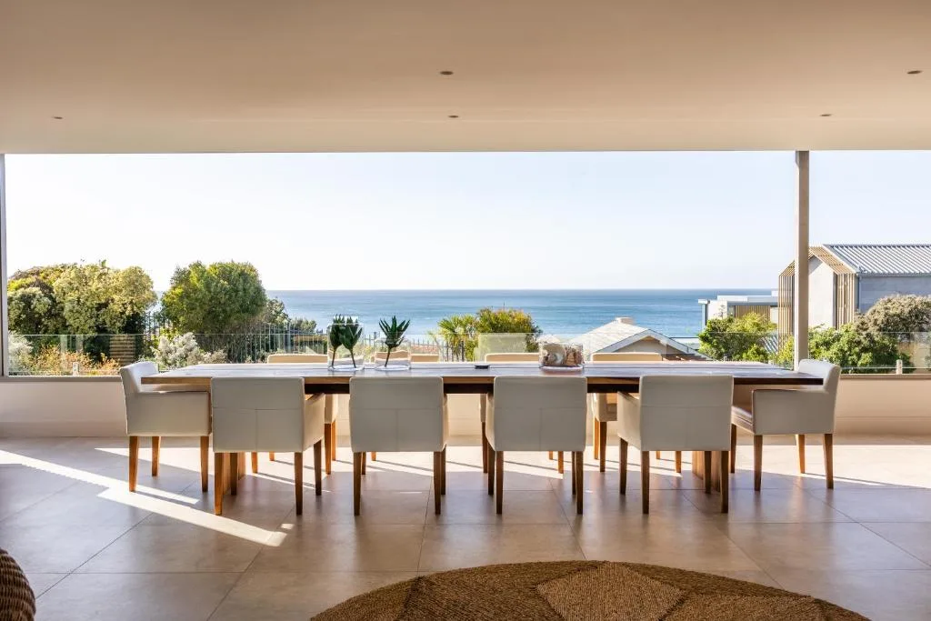 Ocean and coastal landscape visible through expansive windows from deck
