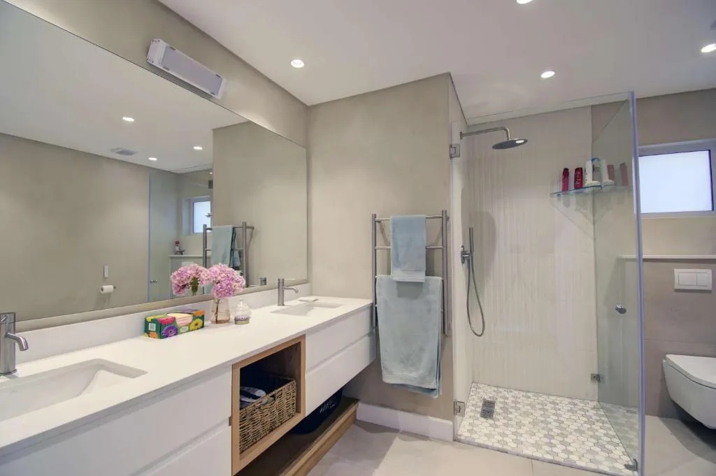 Modern bathroom with double vanity, shower enclosure, and heated towel rail