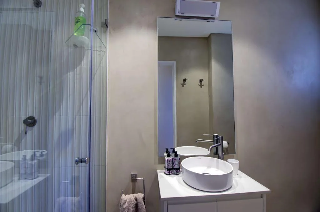 Modern bathroom with dual round white vessel sinks and large mirror