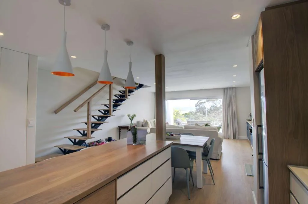 Modern kitchen with wooden countertop overlooking open-plan living space